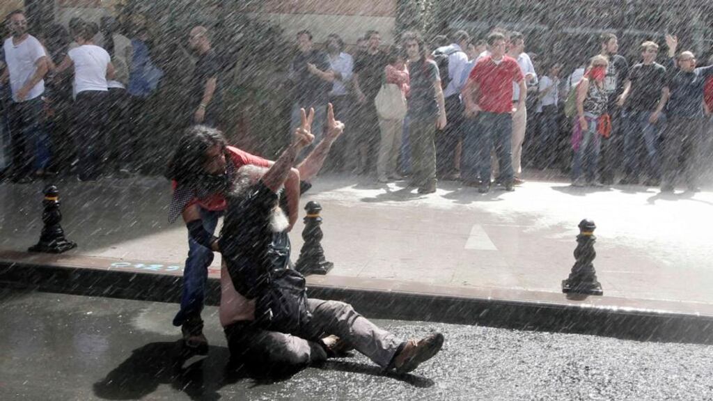 A demonstrator reacts as riot police use water cannon to disperse the crowdin Taksim Square in central Istanbul. Photograph: Osman Orsal/Reuters