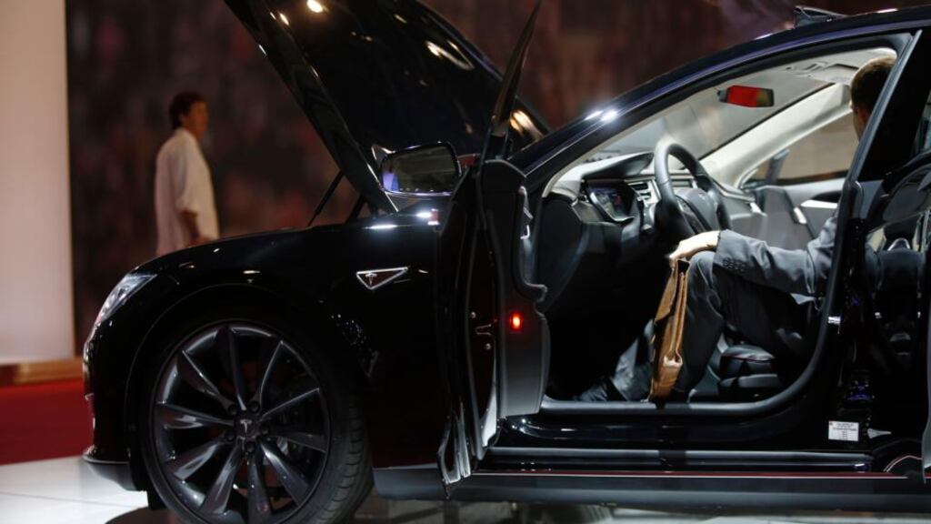 A visitor sits in the driver’s seat of a Tesla Model S at the Paris Motor Show on the final preview day in Paris, France.  Photograph: Simon Dawson/Bloomberg