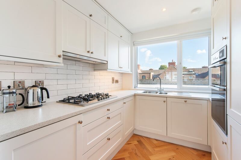 The kitchen has herringbone timber flooring