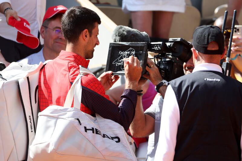 Novak Djokovic writes in Serbian on the camera lens a political statement, 'Kosovo is the heart of Serbia. Stop the violence' about the tensions between Kosovo and Serbia after his first round victory in the French Open at  Stade Roland-Garros in Paris.