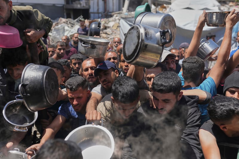 Palestinians receive donated food at a distribution centre in Beit Lahia, northern Gaza. Photograph: Jehad Alshrafi/AP