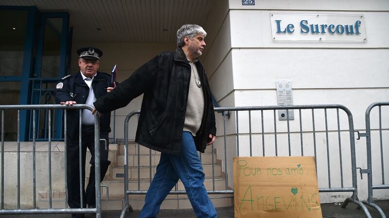 A placard reads ‘For our friends from Angers’ as the departmental director of public safety Francis Wetta (L) and Chief Superintendent of the Regional Judicial Police Service  Lucien Arleri leave a building in which four people were killed and several others injured after a balcony collapsed, on Saturday night in Angers, western France. Photograph: Jean-Francois Monier/AFP/Getty Images