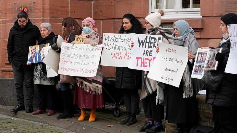 Syrian women hold banners  in front of the court in Koblenz on Thursday. Photograph: Martin Meissner/AP