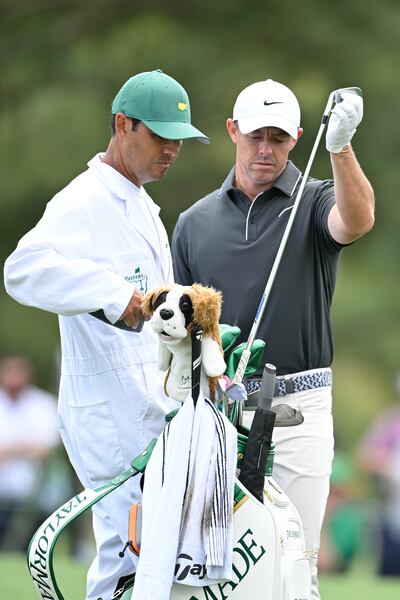 Rory McIlroy pulls a club from his bag as Harry Diamond looks on during the Masters at Augusta. Photograph: Ben Jared/PGA Tour via Getty Images