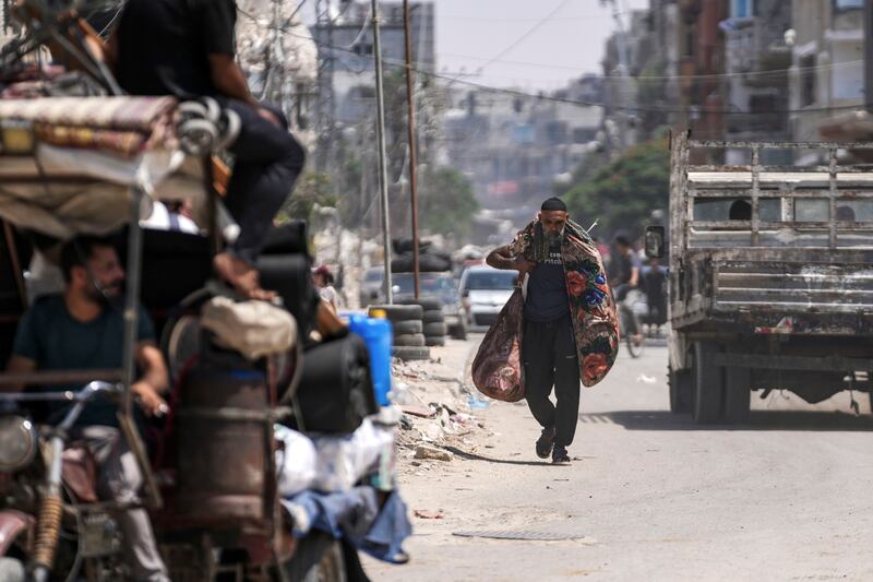 A Palestinian carries his belongings as he evacuates Maghazi refugee camp in the central Gaza Strip, as part of a mass evacuation ordered by the Israeli military ahead of an operation  Photograph: Abdel Kareem Hana/AP