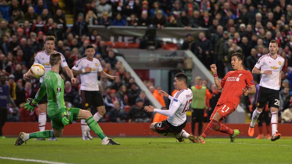 Liverpool Roberto Firmino shoots past Manchester United goalkeeper David de Gea to score his team’s second goal during the Europa League round of 16 first-leg match at Anfield. Photograph: Paul Ellis/AFP/Getty Images