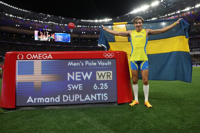 Gold medalist Armand Duplantis poses in front of the scoreboard after setting a new world record at the Olympic Games (Photo by Patrick Smith/Getty Images)