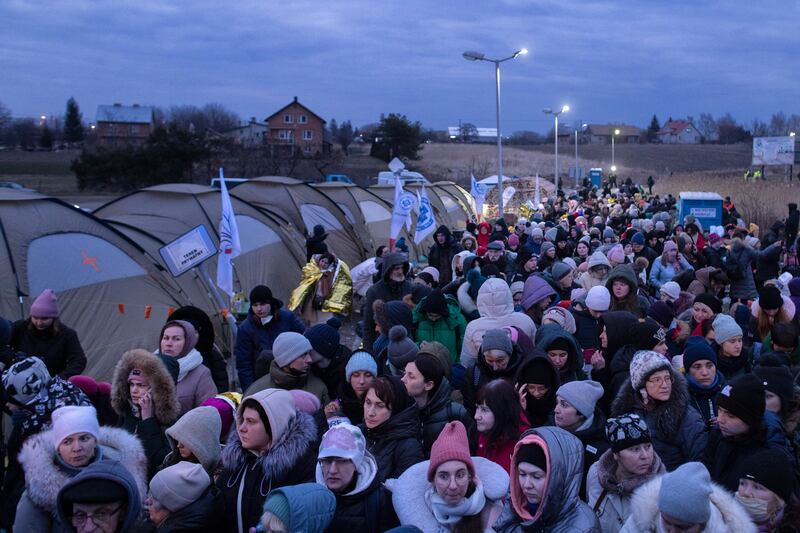 Refugees from Ukraine wait for a bus to continue their journeys after crossing the border to Medyka, Poland, in March 2022. Photograph: Maciek Nabrdalik/New York Times
                      