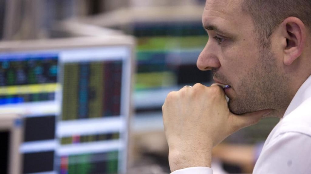 A stockbrokerstudies share prices on his computer screens. Photograph: Chris Ratcliffe/Bloomberg News