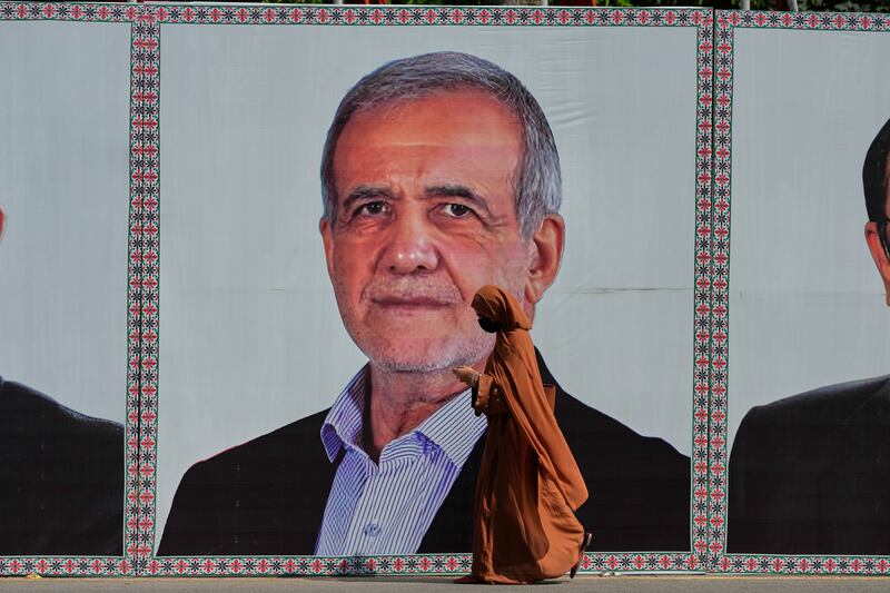 A woman walks past a billboard welcoming Iranian president Masoud Pezeshkian to Islamabad, Pakistan, on June 23rd. Photograph: Anjum Naveed/AP