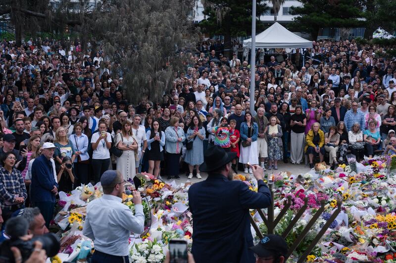 A rabbi lights three candles for Hanukkah during a memorial service on Tuesday near the Bondi Pavilion for victims of the mass shooting at Bondi Beach. Photograph: Matthew Abbott/The New York Times
