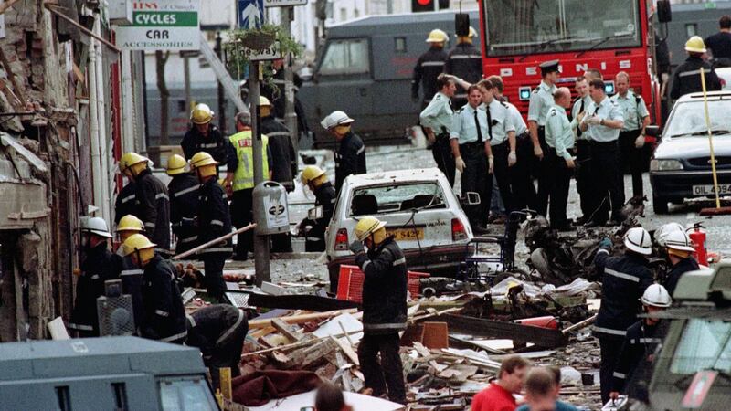 Police officers and firefighters inspecting the damage caused by a bomb explosion in Market Street, Omagh.  Photograph: Paul McErlane/ PA Wire