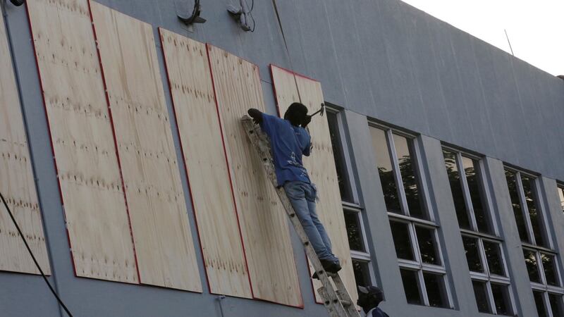 Workers cover the windows at a building as Hurricane Matthew approaches in Kingston, Jamaica on Saturday. Photograph: Reuters