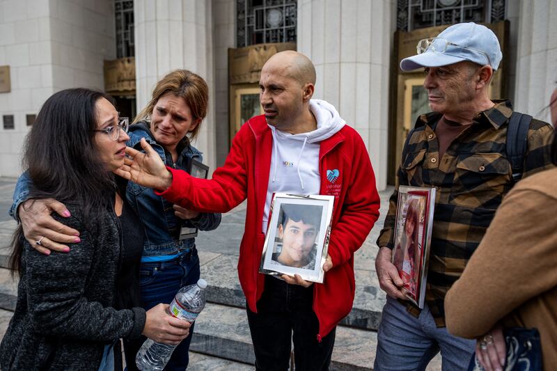 Parents hold photos of their children outside the Los Angeles superior court. Photograph: Ethan Swope/Getty Images