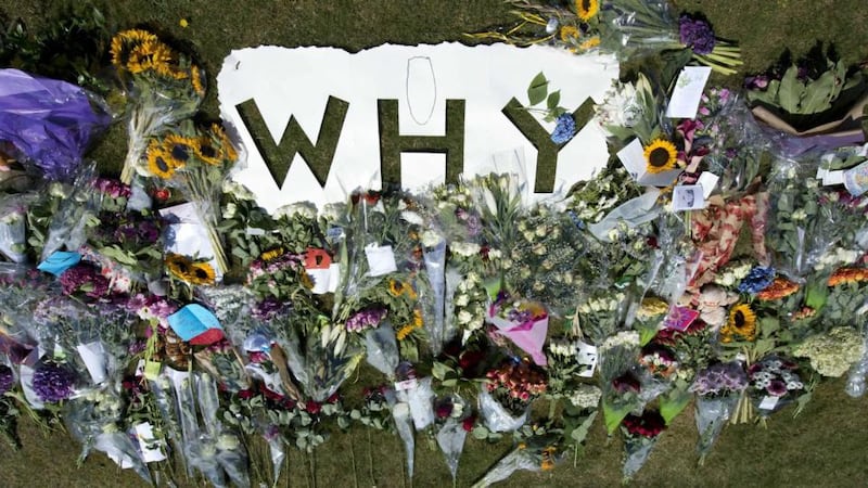 Flowers in tribute to the victims of flight MH17 are laid around a cutout reading ‘Why’, near the entrance to the military airport in Eindhoven, southern Netherlands. Photograph: Marcel van Hoorn/ EPA