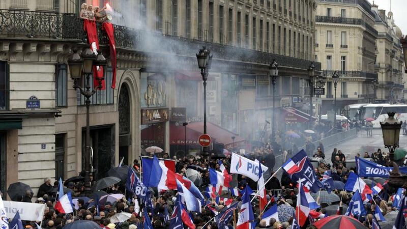 Femen activists (upper left) demonstrate on a balcony during a rally called by France’s far-right political party Front National (FN)  in Paris. Photograph: Kenzo Tribouillard/AFP/Getty Images