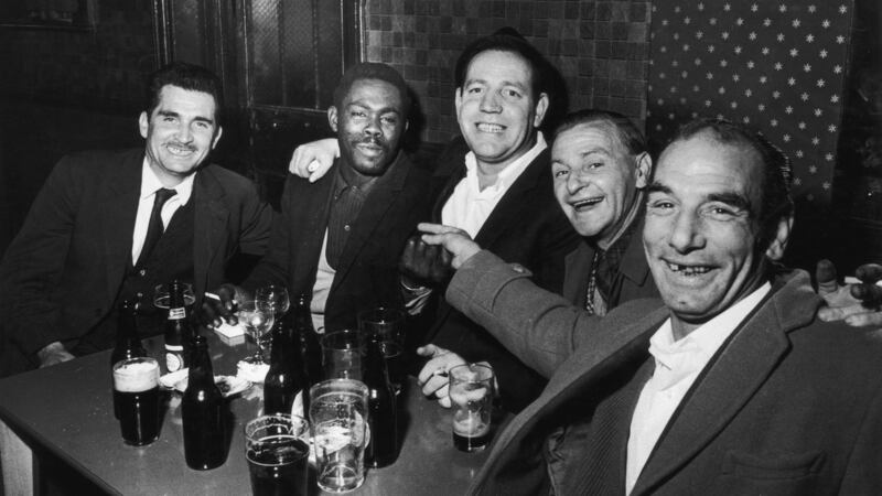 1965: A Jamaican carpenter and a group of Irish labourers drinking in the Coach and Horses, a London pub. Photograph: Val Wilmer/Getty Images