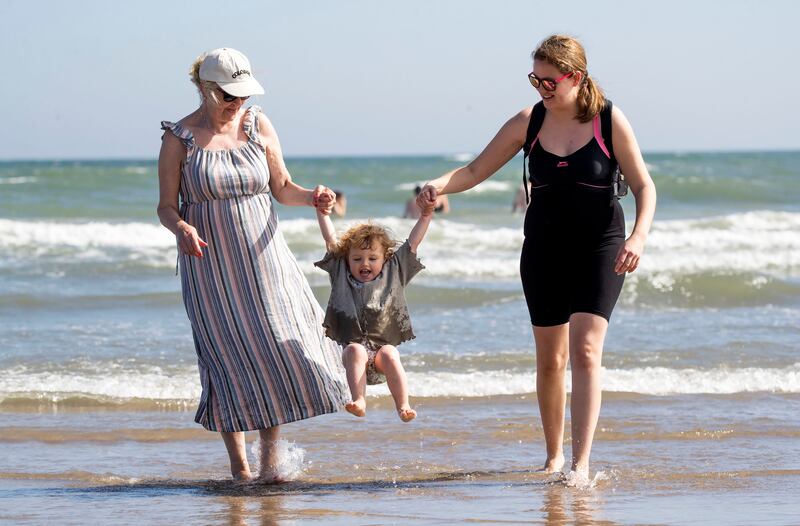 05/09/2023 Leslie Fox from Castleknock  and her daughter, Zara (2), and mother, Brenda splash in the waters of Portmarnock Beach. Photograph: Colin Keegan/Collins