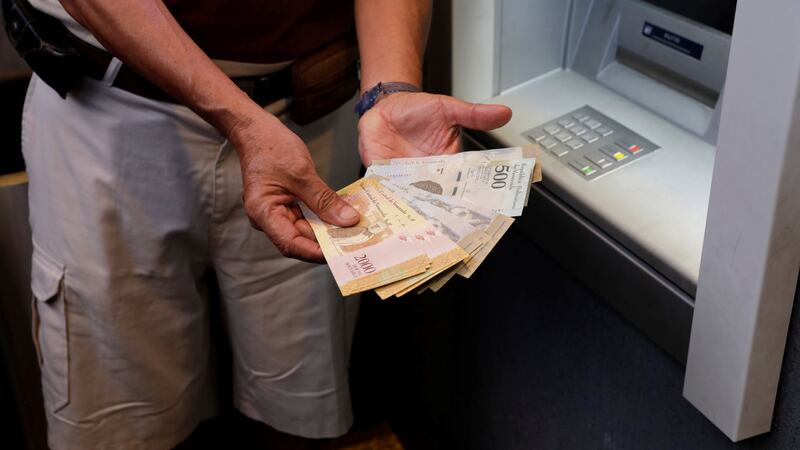 A man displays Bolivar notes after withdrawing them from an automated teller machine  in Caracas, Venezuela, this weekend. Photograph: Marco Bello/Reuters
