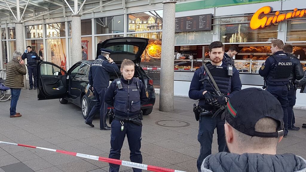 Police officers guard a car in front of a business building in Heidelberg, western Germany, where a driver ploughed into pedestrians before being shot by police on Saturday. Photograph: Rene Priebe/EPA
