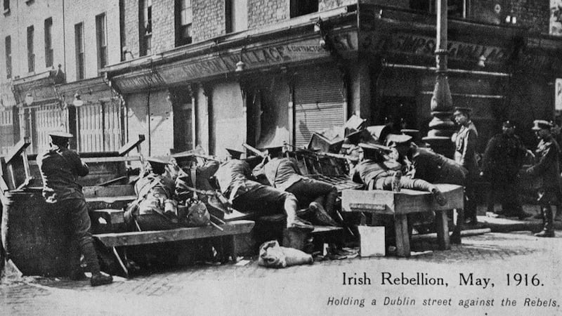 Towards the end of, and also after the Rising, there were many posed photographs showing British troops poised for action. This image shows troops at a barricade at the intersection of Moore and Parnell Streets.	Photograph: Allen Library