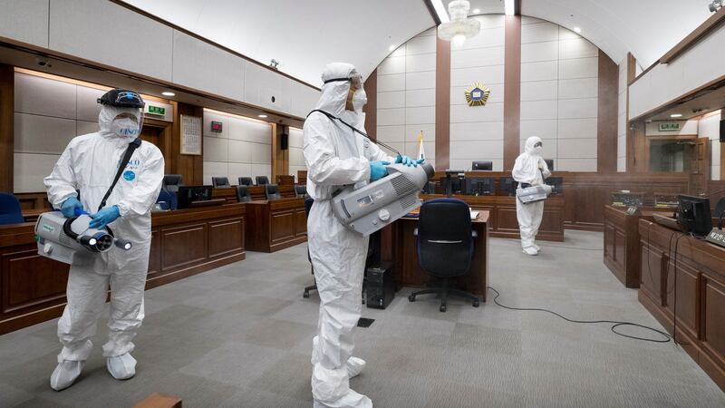 Sanitary workers clad in protective gear disinfect the Seoul Central District Court in southern Seoul, South Korea, on Friday Photograph: Yonhap/EPA