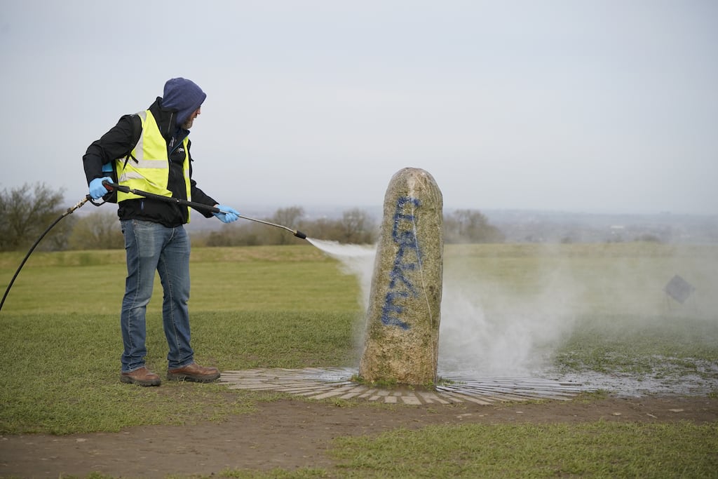 A worker from the Office of Public Works cleaning graffiti off the Lia Fail standing stone on the Hill of Tara near Skryne, Co Meath.