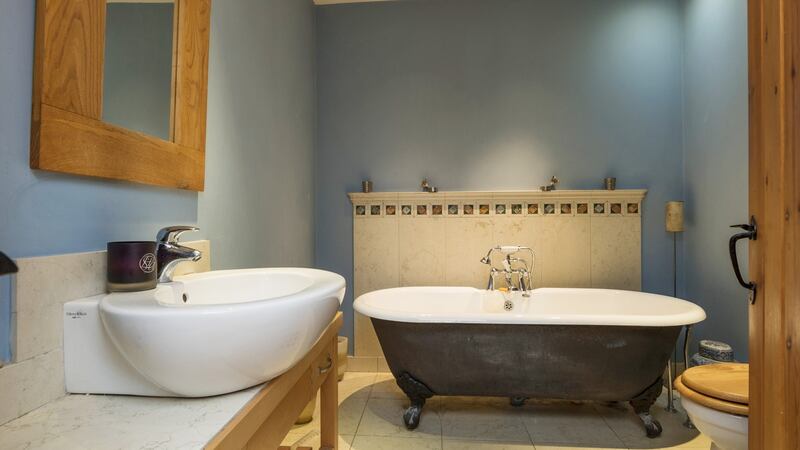The  bathroom is stylishly finished with an antique claw-foot bath and contemporary Villeroy & Boch sink
