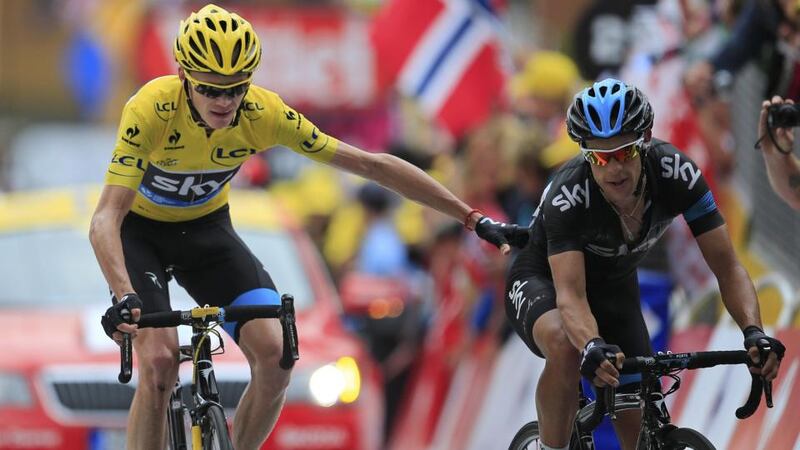 Chris Froome, wearing the overall leader’s yellow jersey, says thanks to team-mate Richie Porte of Australia, right, as they cross the finish line of the 18th stage of the Tour de France  on Alpe-d’Huez. Photograph: Peter Dejong/AP