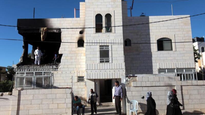 Palestinians at the partially burned home of one of the  suspects in the kidnapping and murder of three Israeli teenagers, after the Israeli army set fire to the building in the West Bank village of Halhoul, near Hebron, today. Photograph: EPA
