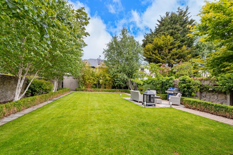 A sunny patio lies halfway down a garden path