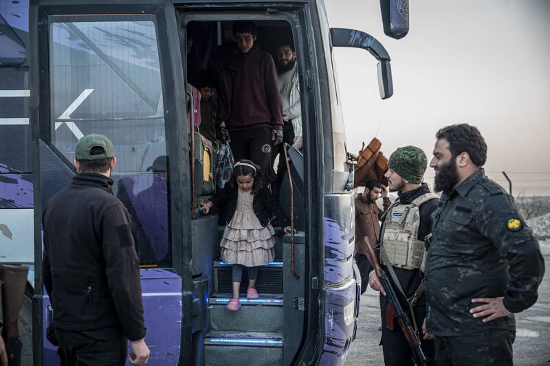 A young girl disembarks a bus at Aq Burhan camp in northwest Syria. Photograph: Sally Hayden