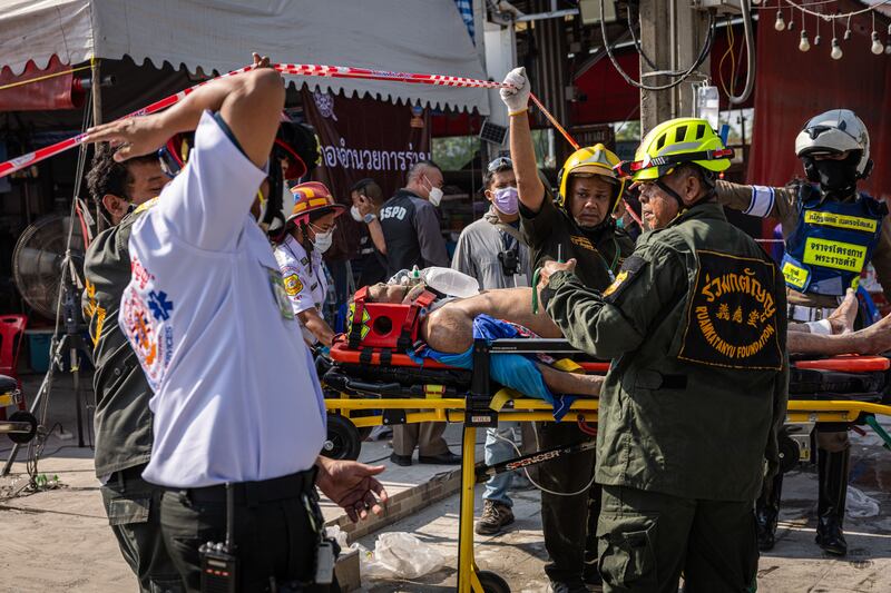 Myanmar and Thailand earthquake: An injured construction worker is transported out of a collapsed building in Bangkok. Photograph: Lauren Decicca/Getty Images 