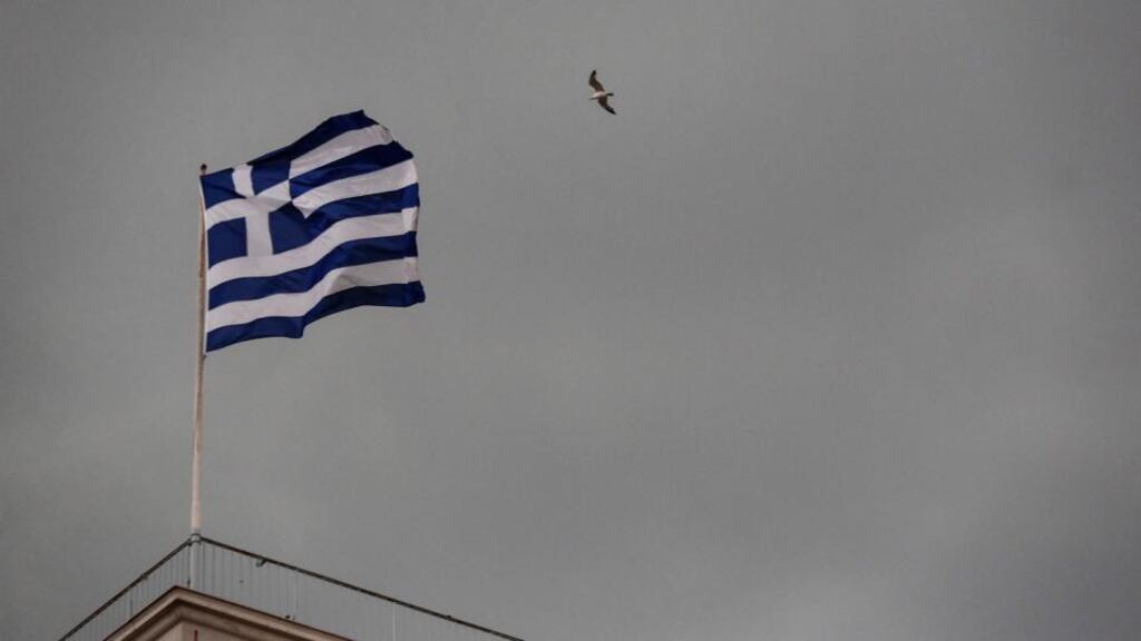 A seagull flies over a Greek national flag during a demonstration in Athens. Photograph: Yorgos Karahalis/Bloomberg.