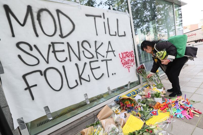 A woman lays flowers next  to a banner reading "Courage to the Swedish people" following Monday's terrorist attack against Swedish soccer supporters in Brussels. Photograph: Benoit Doppagne/Getty/AFP