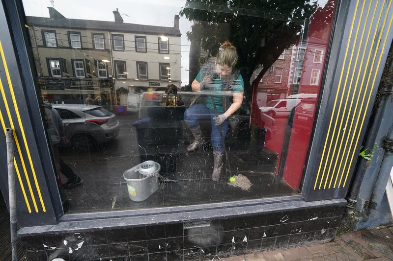 A shop owner mops up in the window of a premises on Main Street. Photograph: Brian Lawless/PA Wire