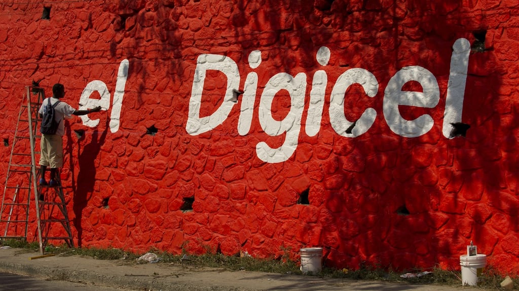 Workers paint the Digicel brand on a wall in Haiti. Digicel operates in 31 markets in the Caribbean, Central America and the Asia-Pacific region. Photograph: Ken Cedeno/Digital/Corbis via Getty Images