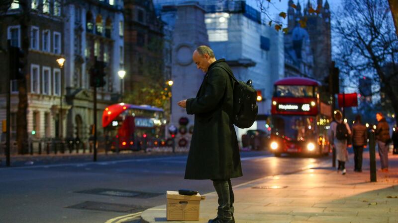 Dominic Cummings waits with a box of possessions on Whitehall after departing  10 Downing Street. Photographer: Hollie Adams/Bloomberg