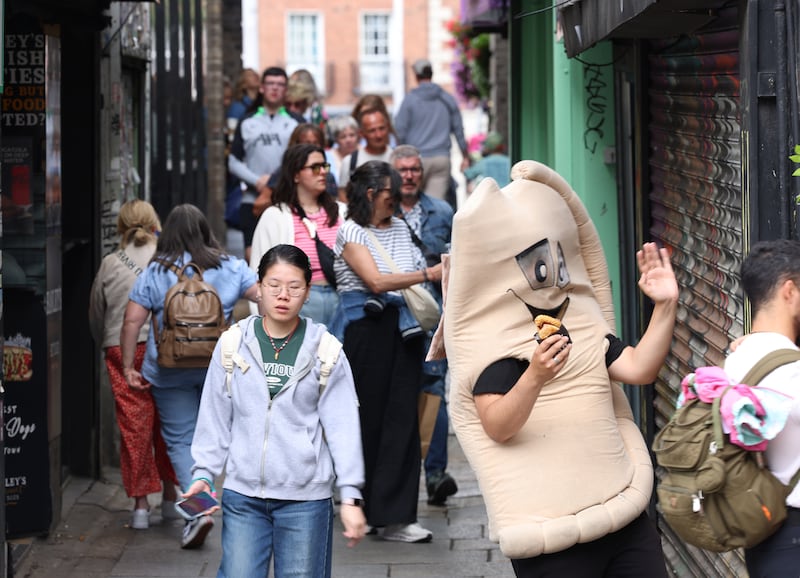 People walk through Merchant's Arch in Temple Bar, Dublin. Photograph: Dara Mac Dónaill