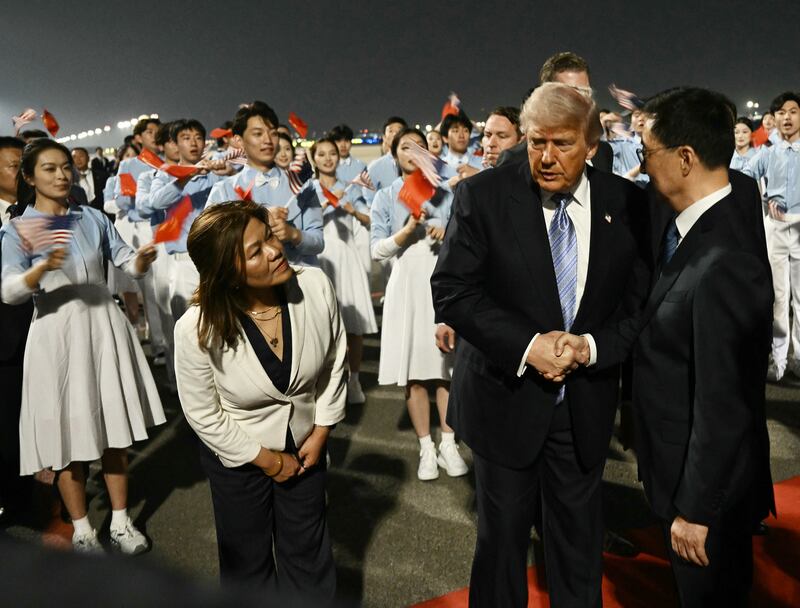 US President Donald Trump (C) is greeted by China's Vice President Han Zheng upon arriving at Beijing Capital Airport in Beijing on May 13, 2026. (Photo by Brendan SMIALOWSKI / AFP via Getty Images)