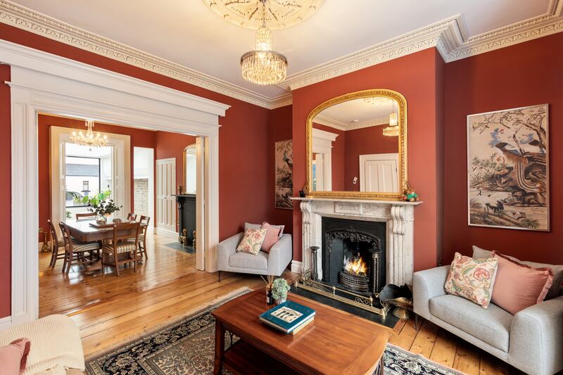 The livingroom features a substantial grey-marble fireplace. It opens into the diningroom through original double doors