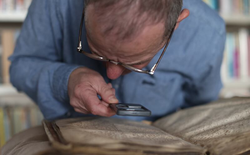 Dr John Gillis looks closely at The Red Book of Ossory, a replica of which is now on display at St Canice’s Cathedral in Kilkenny