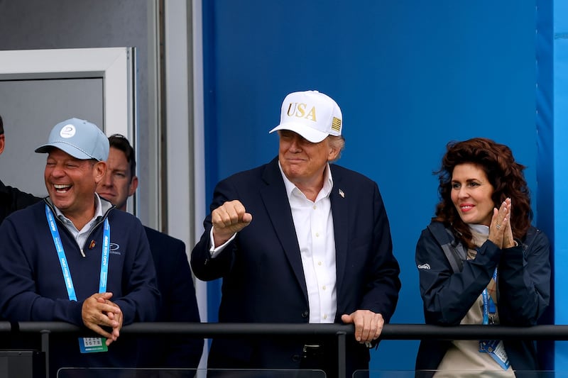 US president Donald Trump makes a gesture to Rory McIlroy after finishing his round on the eighteenth. Photograph: Ben Brady/INPHO