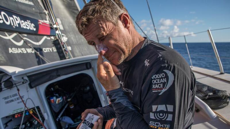 Leg six to Auckland, day 14 on board Sun Hung Kai/Scallywag. John Fisher applies some sun cream.