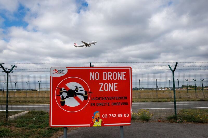 A 'No Drone Zone' sign at Brussels aiport while a passenger plane takes off. Photograph: EPA