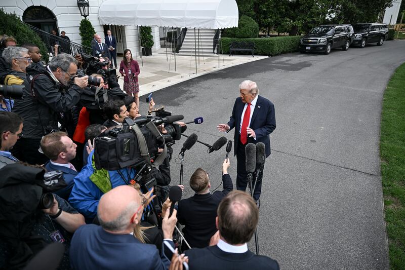 President Donald Trump speaks to reporters as he departed the White House, bound for a trip to Britain. Photograph: Kenny Holston/The New York Times
                      