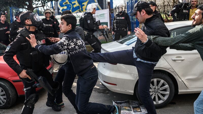 A plainclothes police officer kicks a demonstrator as Turkish anti-riot police officers disperse supporters in front of the headquarters of the Turkish daily newspaper Zaman in Istanbul on March 5, 2016, after Turkish authorities seized the headquarters in a midnight raid. Photograph: Ozan Kose/AFP/Getty Images