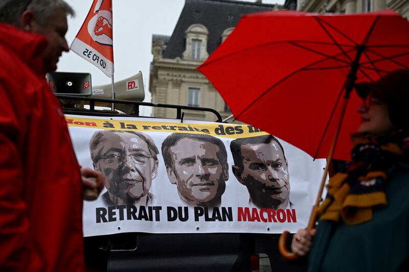 Protesters with a banner showing prime minister Elisabeth Borne, president Emmanuel Macron and labour minister Olivier Dussopt during a rally in Rennes against the government's pension reform plan. Photograph: Damien Meyer/Getty