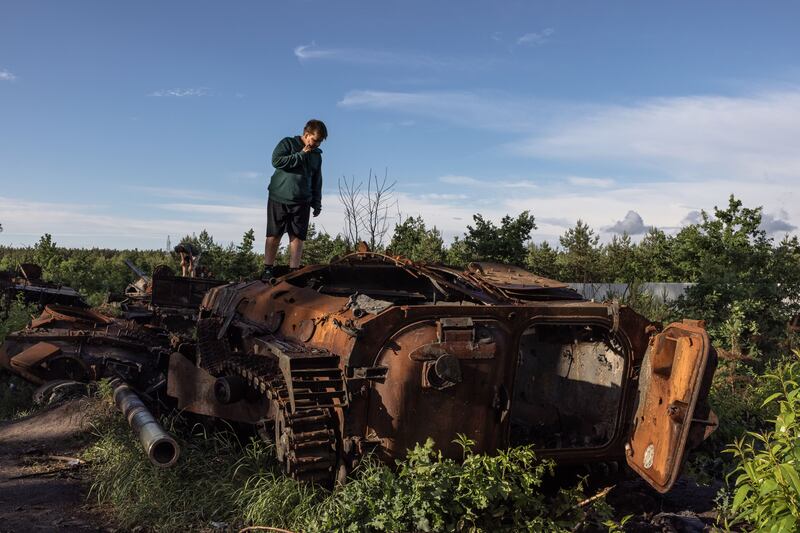 A young boy stands on a destroyed Russian military vehicle near Irpin, the Kyiv region, Ukraine, 22 June 2022. Photograph: Roman Pilipey/EPA-EFE