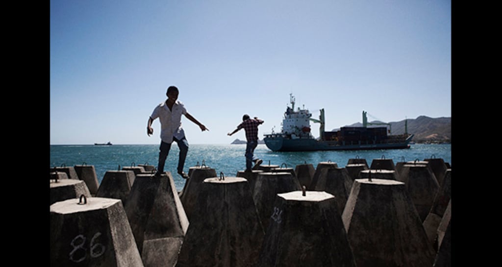 Young boys play on concrete blocks at Dili’s port, as a container ship sails in. Photograph: Cedric Arnold/realfeatures.com